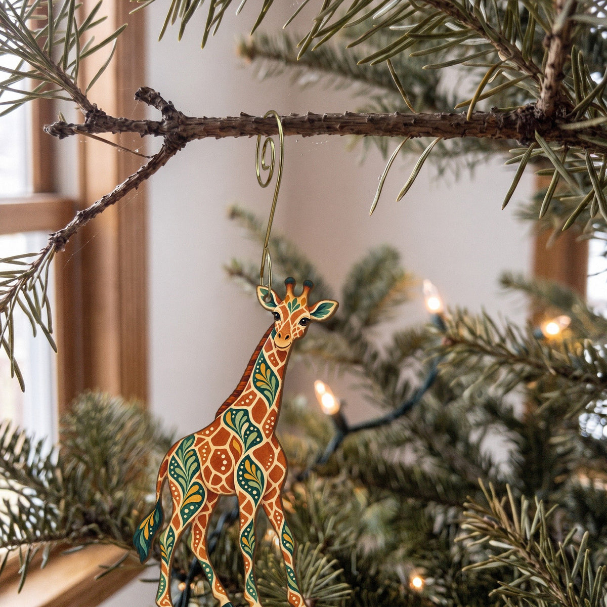 Laser-cut maple wood Reticulated Giraffe folk art ornament O339 hanging on a fir branch, made in USA