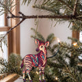 Laser-cut maple wood Okapi folk art ornament O340 hanging on a fir branch, made in USA