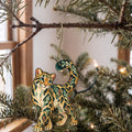 Laser-cut maple wood Clouded Leopard folk art ornament O347 hanging on a fir branch, made in USA