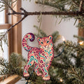 Laser-cut maple wood Amur Leopard folk art ornament O348 hanging on a fir branch, made in USA
