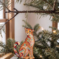 Laser-cut maple wood Cheetah folk art ornament O350 hanging on a fir branch, made in USA
