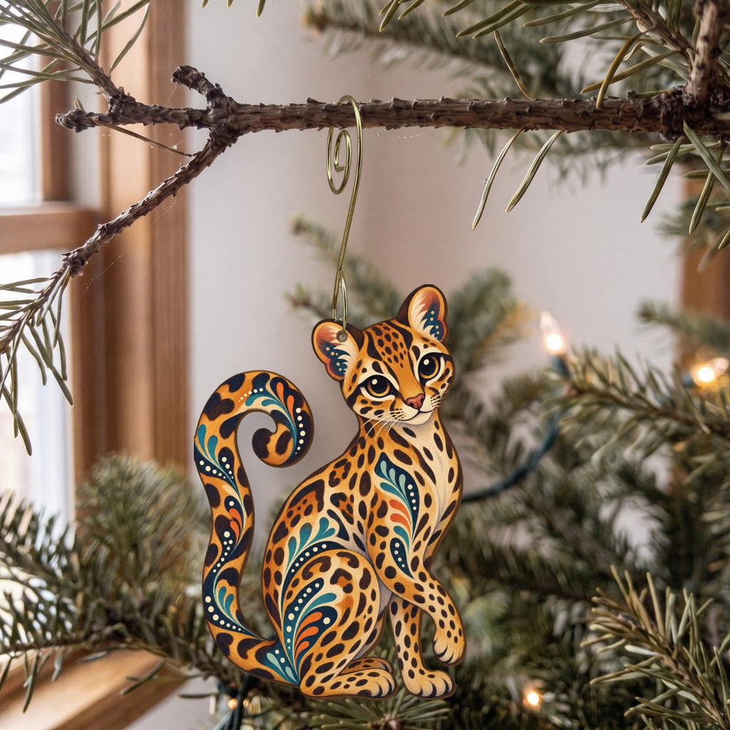 Laser-cut maple wood Margay folk art ornament O354 hanging on a fir branch, made in USA