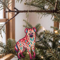 Laser-cut maple wood Spotted Hyena folk art ornament O360 hanging on a fir branch, made in USA
