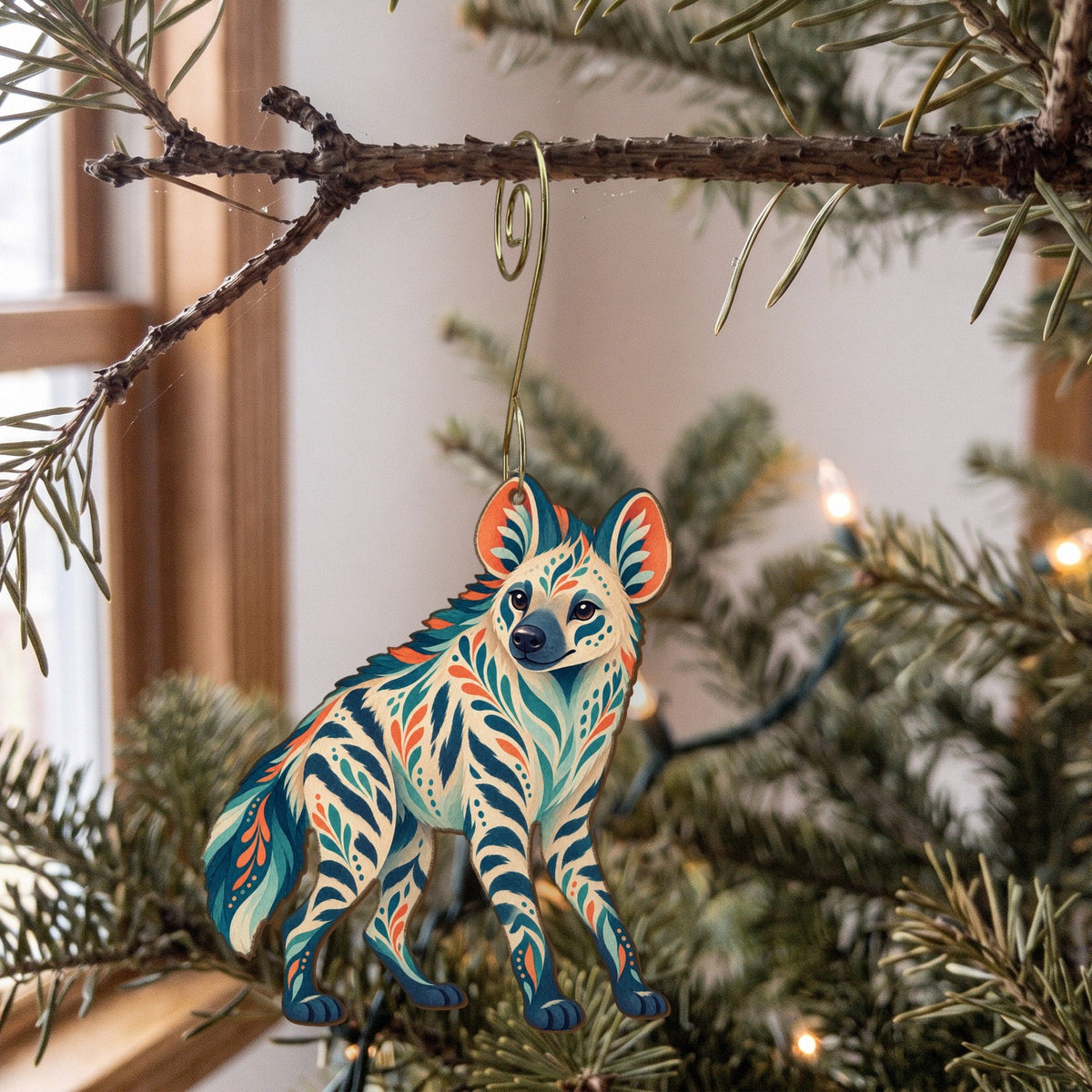Laser-cut maple wood Striped Hyena folk art ornament O361 hanging on a fir branch, made in USA