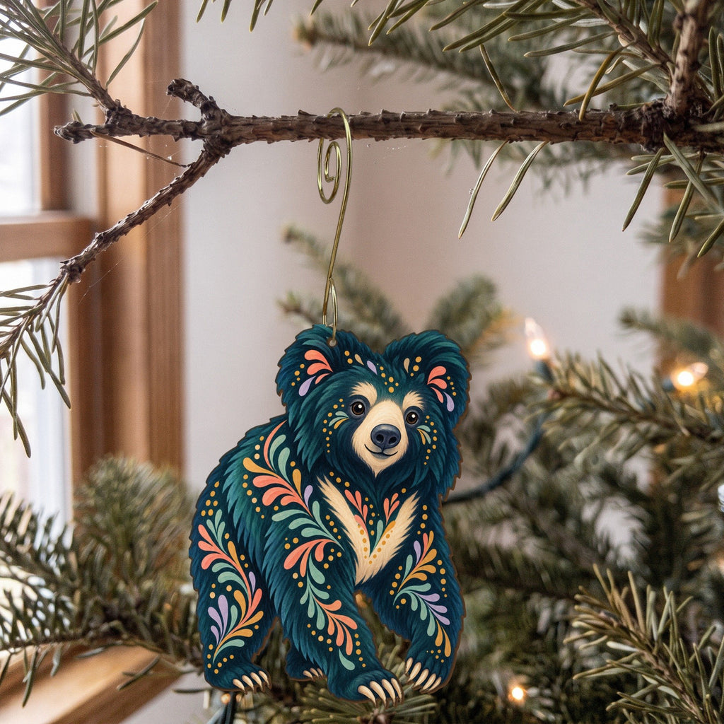 Laser-cut maple wood Sloth Bear folk art ornament O367 hanging on a fir branch, made in USA