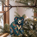 Laser-cut maple wood Sloth Bear folk art ornament O367 hanging on a fir branch, made in USA