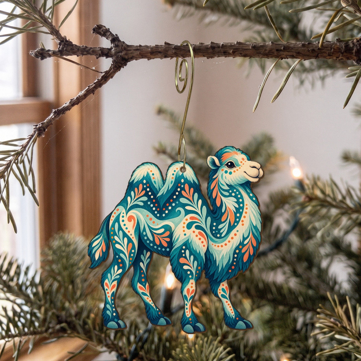 Laser-cut maple wood Bactrian Camel folk art ornament O377 hanging on a fir branch, made in USA