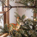 Laser-cut maple wood Guanaco folk art ornament O379 hanging on a fir branch, made in USA