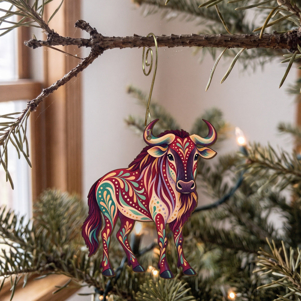 Laser-cut maple wood Wildebeest folk art ornament O382 hanging on a fir branch, made in USA