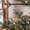 Laser-cut maple wood Gemsbok folk art ornament O383 hanging on a fir branch, made in USA