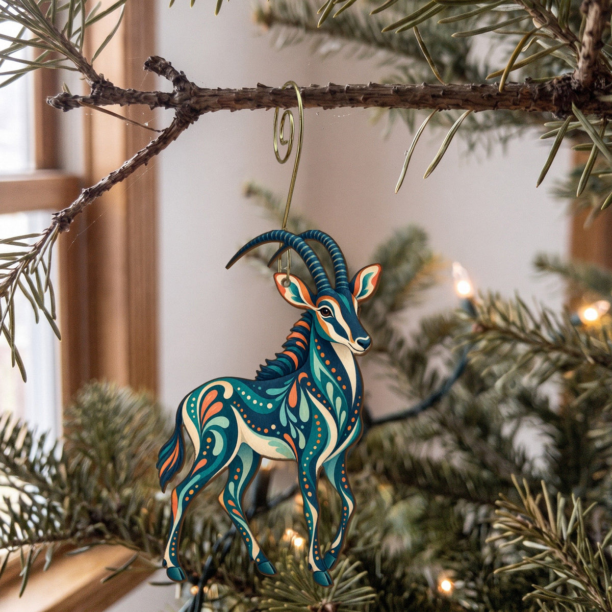 Laser-cut maple wood Sable Antelope folk art ornament O385 hanging on a fir branch, made in USA