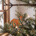 Laser-cut maple wood Bongo Antelope folk art ornament O387 hanging on a fir branch, made in USA