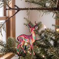 Laser-cut maple wood Impala folk art ornament O388 hanging on a fir branch, made in USA