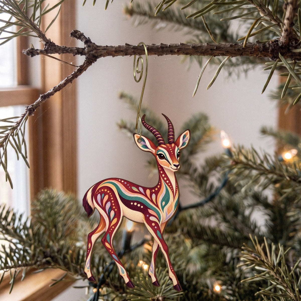 Laser-cut maple wood Thomson's Gazelle folk art ornament O390 hanging on a fir branch, made in USA