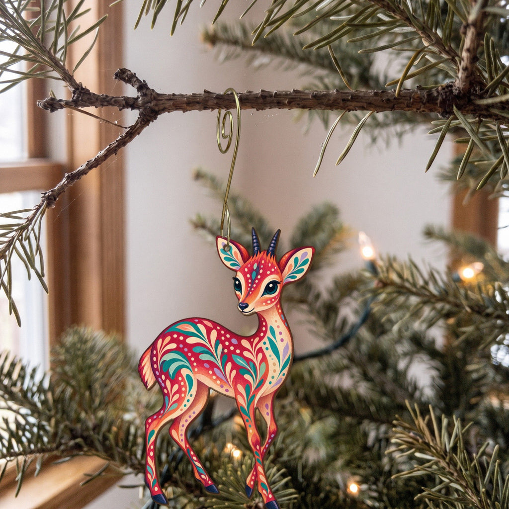 Laser-cut maple wood Dik-Dik folk art ornament O392 hanging on a fir branch, made in USA