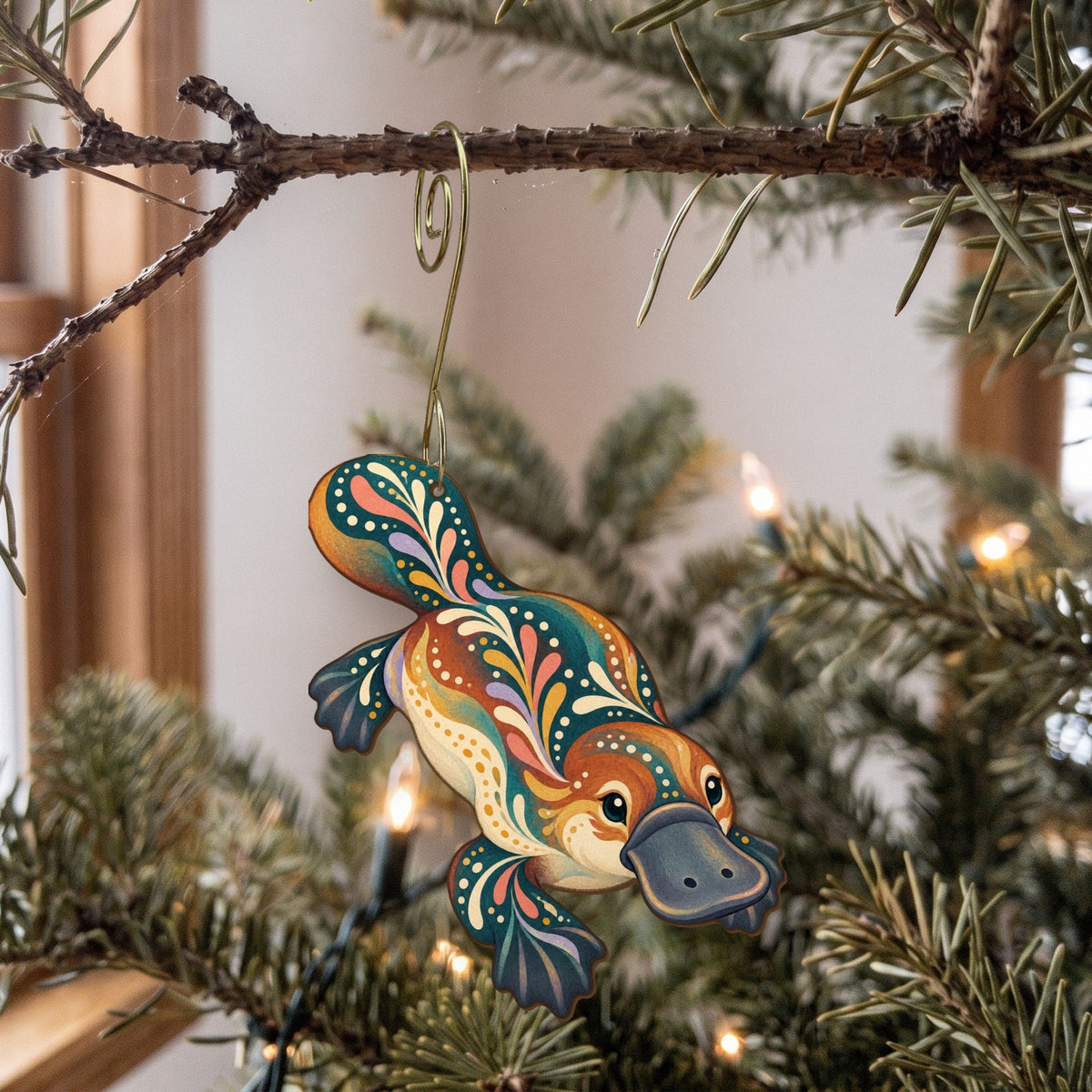 Laser-cut maple wood Platypus folk art ornament O399 hanging on a fir branch, made in USA