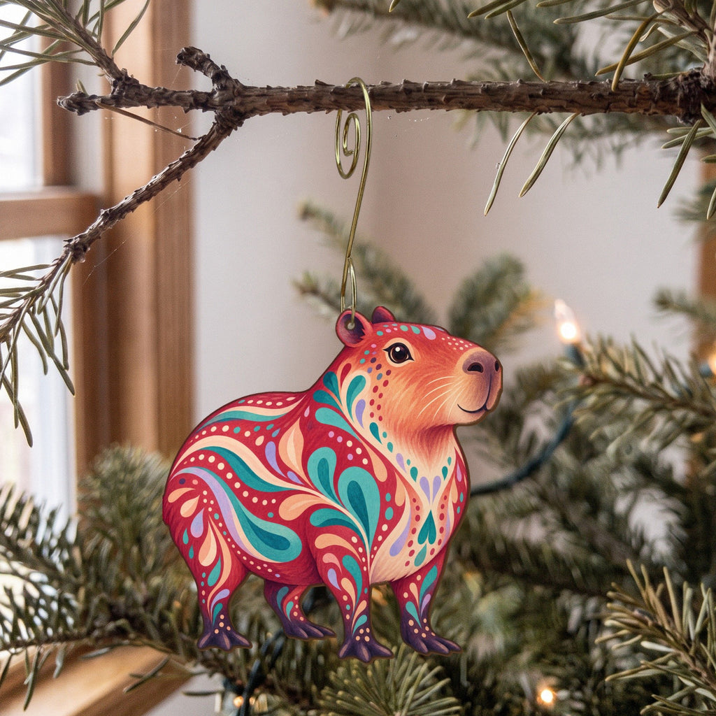 Laser-cut maple wood Capybara folk art ornament O400 hanging on a fir branch, made in USA