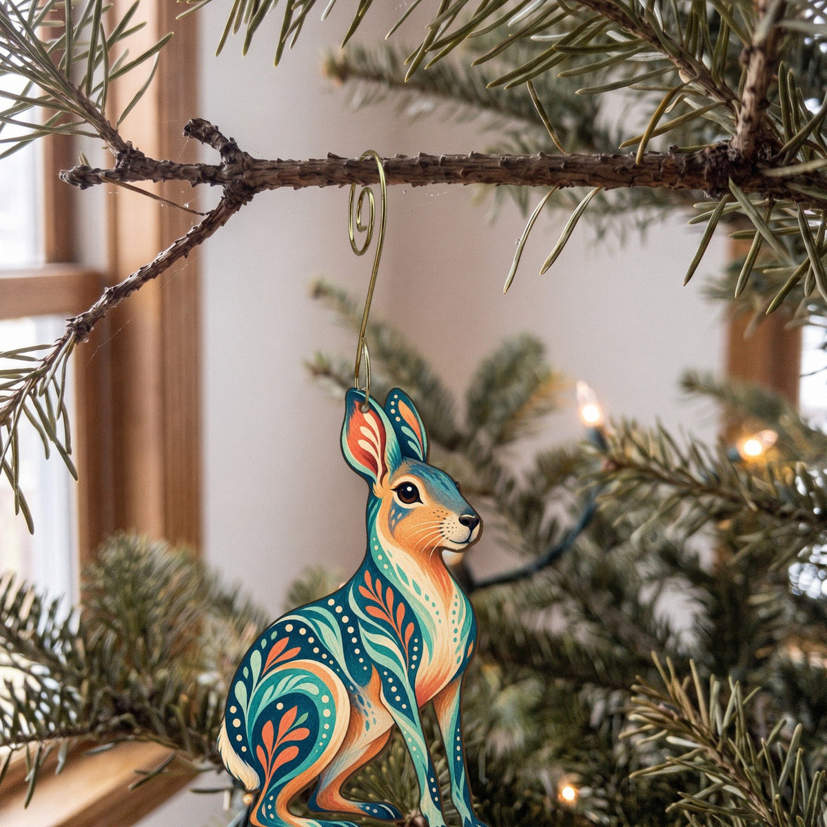 Laser-cut maple wood Patagonian Mara folk art ornament O401 hanging on a fir branch, made in USA