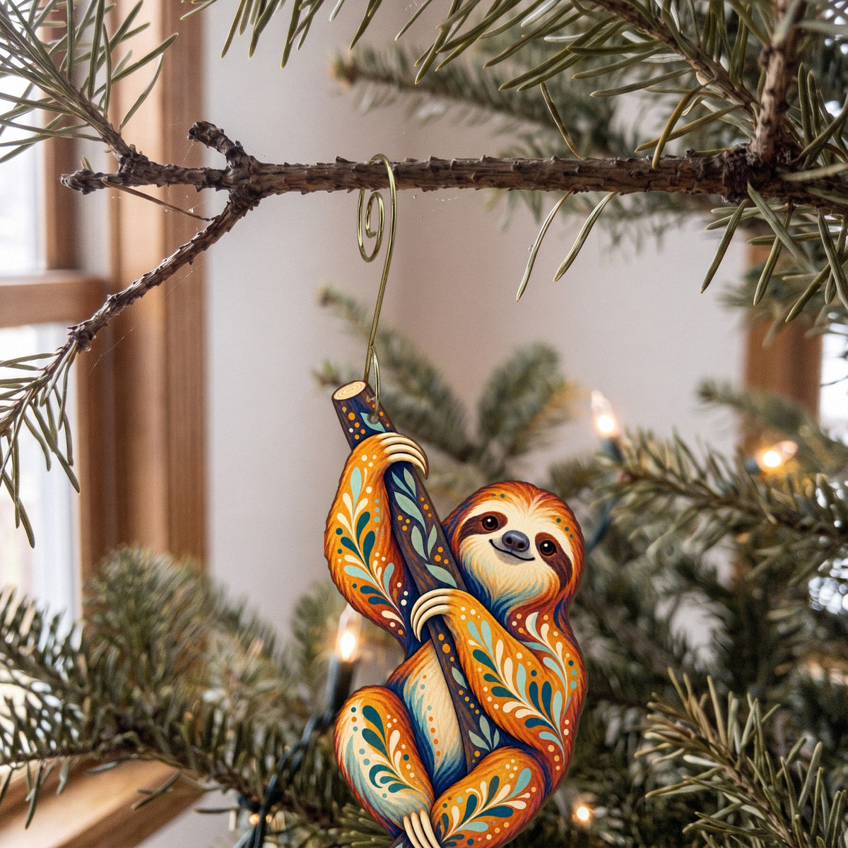 Laser-cut maple wood Three-Toed Sloth folk art ornament O402 hanging on a fir branch, made in USA