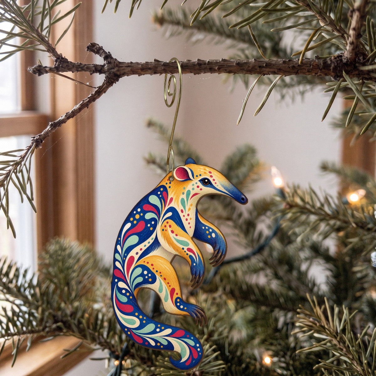 Laser-cut maple wood Tamandua folk art ornament O405 hanging on a fir branch, made in USA