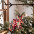Laser-cut maple wood Aardvark folk art ornament O406 hanging on a fir branch, made in USA