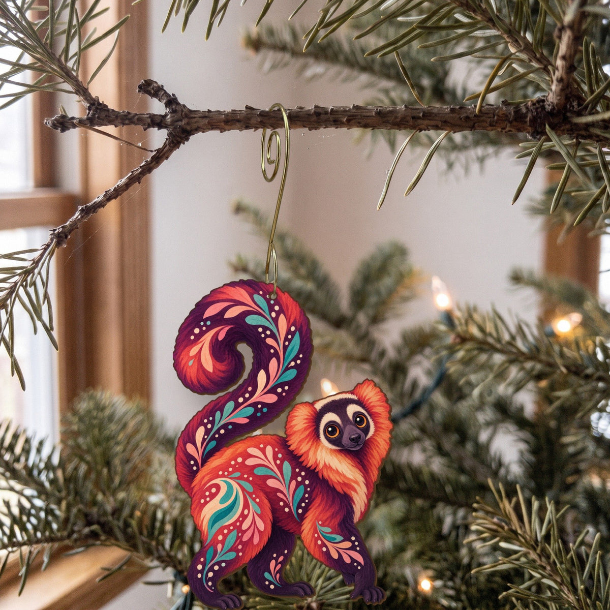 Laser-cut maple wood Red Ruffed Lemur folk art ornament O412 hanging on a fir branch, made in USA