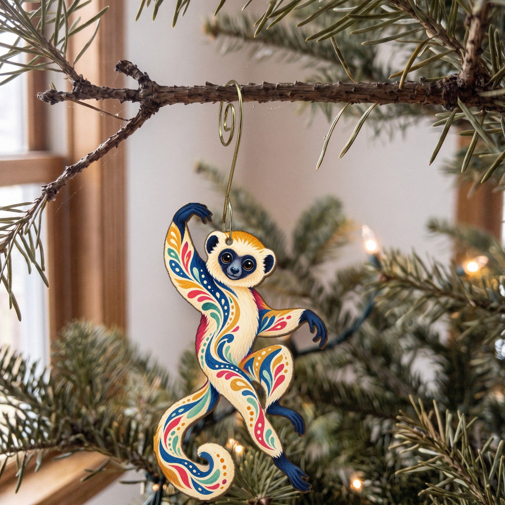 Laser-cut maple wood Sifaka folk art ornament O413 hanging on a fir branch, made in USA