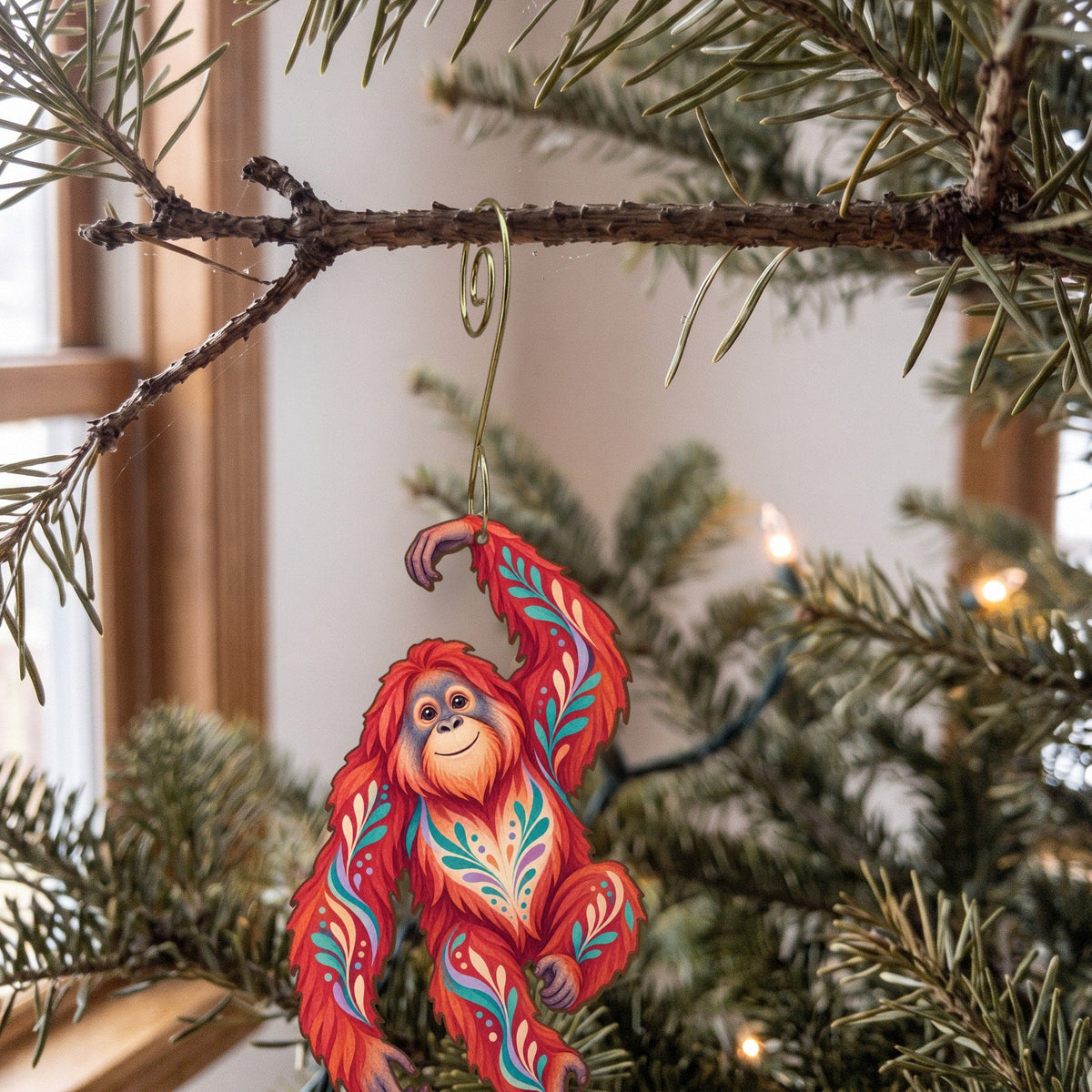 Laser-cut maple wood Orangutan folk art ornament O416 hanging on a fir branch, made in USA