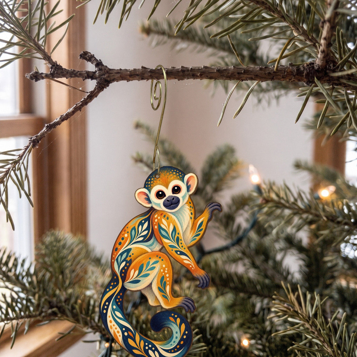 Laser-cut maple wood Squirrel Monkey folk art ornament O426 hanging on a fir branch, made in USA