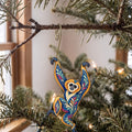Laser-cut maple wood Gibbon folk art ornament O429 hanging on a fir branch, made in USA