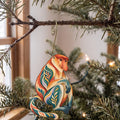 Laser-cut maple wood Proboscis Monkey folk art ornament O431 hanging on a fir branch, made in USA