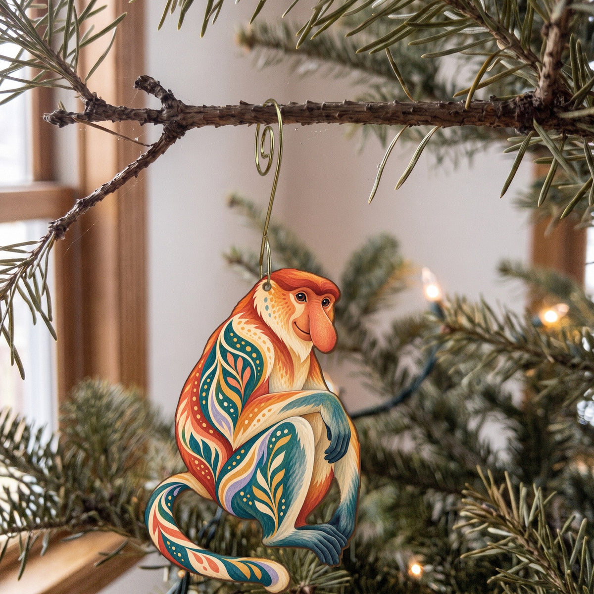 Laser-cut maple wood Proboscis Monkey folk art ornament O431 hanging on a fir branch, made in USA