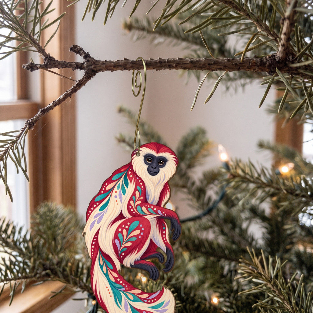 Laser-cut maple wood Colobus Monkey folk art ornament O432 hanging on a fir branch, made in USA
