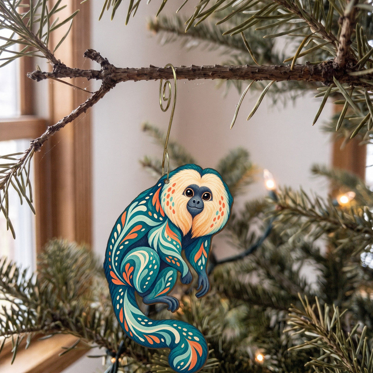 Laser-cut maple wood Saki Monkey folk art ornament O433 hanging on a fir branch, made in USA