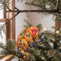 Laser-cut maple wood Bald Uakari folk art ornament O434 hanging on a fir branch, made in USA
