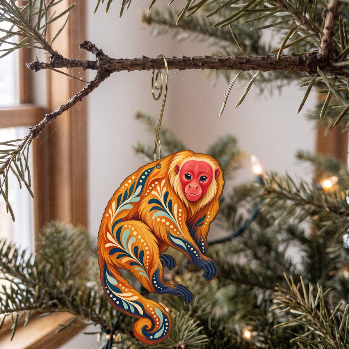Laser-cut maple wood Bald Uakari folk art ornament O434 hanging on a fir branch, made in USA