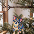 Laser-cut maple wood French Bulldog folk art ornament O445 hanging on a fir branch, made in USA