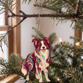 Laser-cut maple wood Border Collie folk art ornament O446 hanging on a fir branch, made in USA