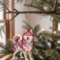 Laser-cut maple wood Siberian Husky folk art ornament O448 hanging on a fir branch, made in USA