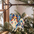 Laser-cut maple wood Papillon Dog folk art ornament O453 hanging on a fir branch, made in USA