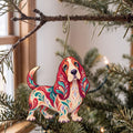Laser-cut maple wood Basset Hound folk art ornament O456 hanging on a fir branch, made in USA