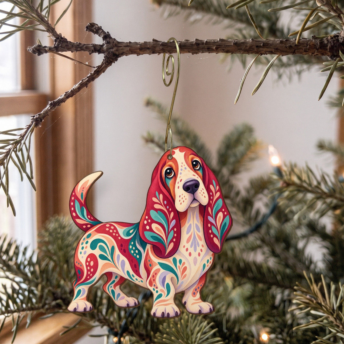 Laser-cut maple wood Basset Hound folk art ornament O456 hanging on a fir branch, made in USA