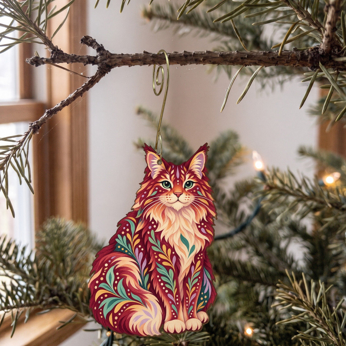 Laser-cut maple wood Maine Coon Cat folk art ornament O462 hanging on a fir branch, made in USA