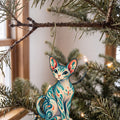 Laser-cut maple wood Sphynx Cat folk art ornament O465 hanging on a fir branch, made in USA
