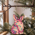 Laser-cut maple wood Angora Rabbit folk art ornament O468 hanging on a fir branch, made in USA