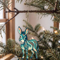 Laser-cut maple wood Donkey folk art ornament O481 hanging on a fir branch, made in USA