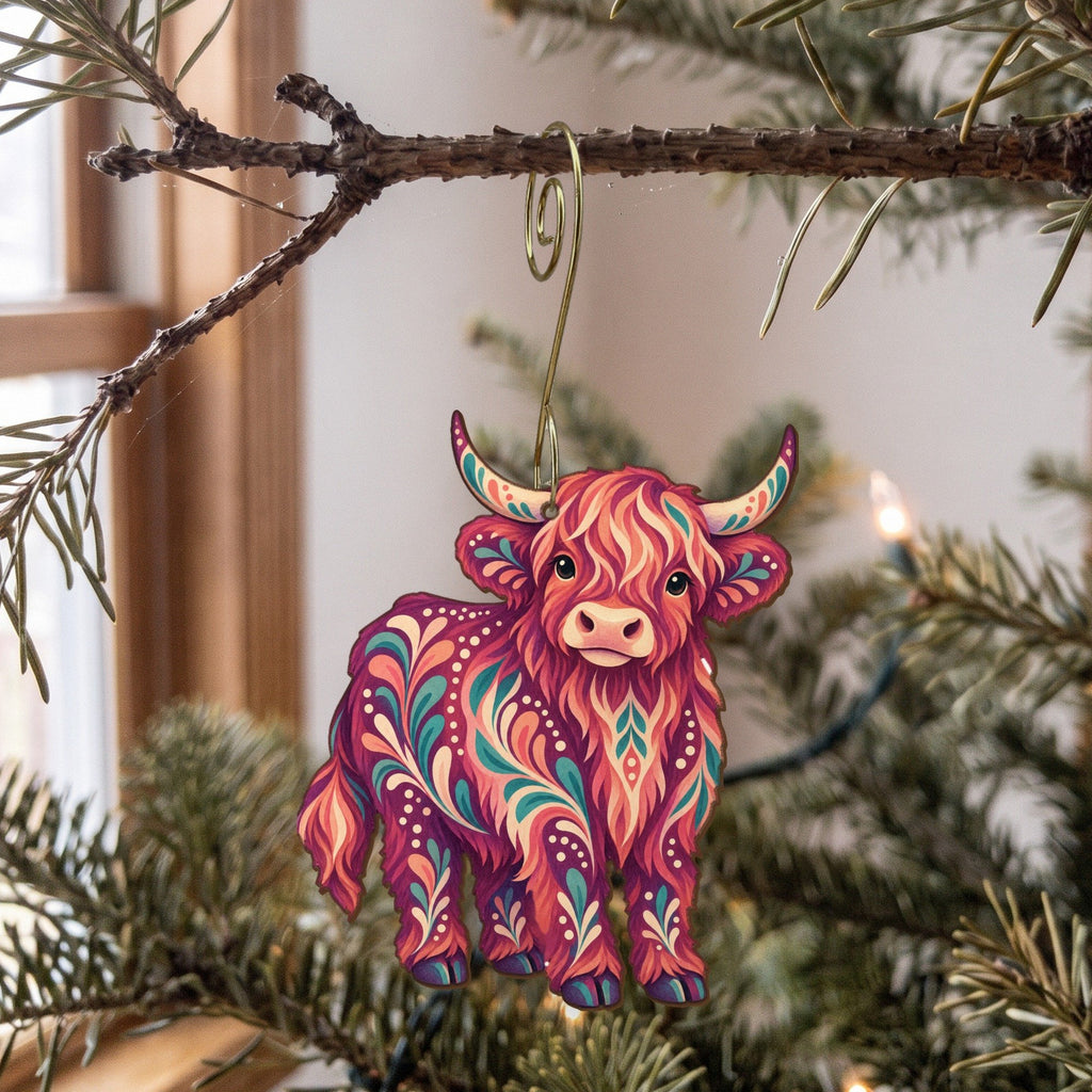 Laser-cut maple wood Highland Cow folk art ornament O484 hanging on a fir branch, made in USA