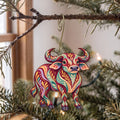 Laser-cut maple wood Water Buffalo folk art ornament O486 hanging on a fir branch, made in USA