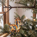 Laser-cut maple wood Nubian Goat folk art ornament O490 hanging on a fir branch, made in USA