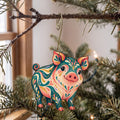 Laser-cut maple wood Pot-Bellied Pig folk art ornament O495 hanging on a fir branch, made in USA
